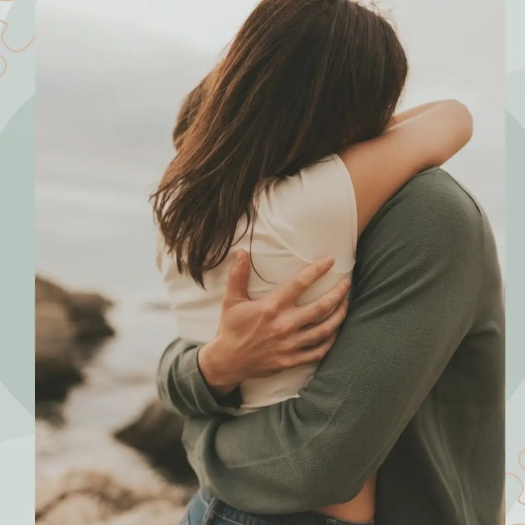 A couple uses the AI hug video tool, as they embrace each other on a rocky beach.