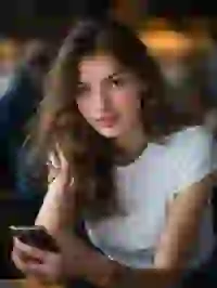 beautiful-woman-in-white-short-sleeve-top Portrait of a smiling blonde woman sitting ceside a desk with a phone in her hand. Template for Undress AI.