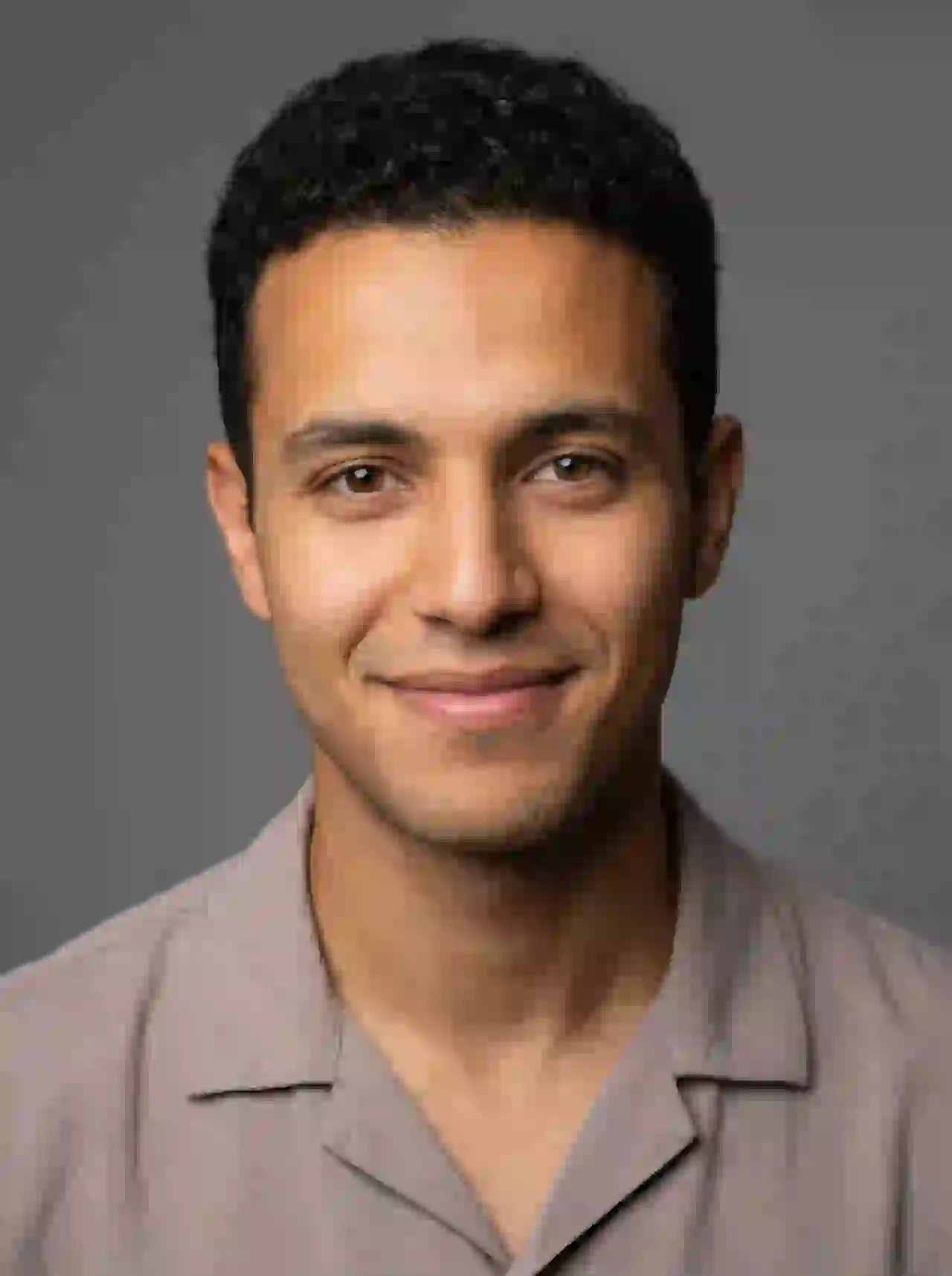 North African man with short hair and warm smile in neutral top. Template for photo face swap.