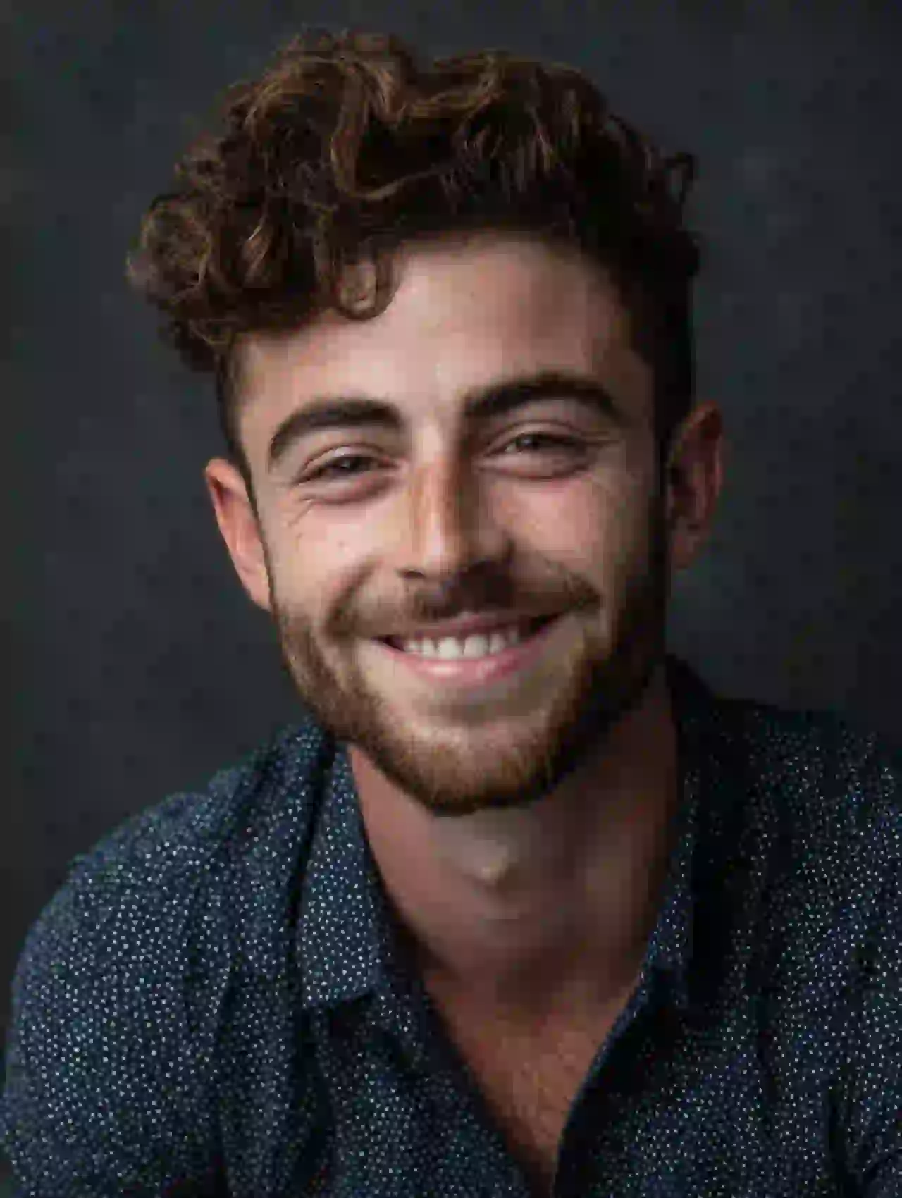 Young man with curly brown hair and beard smiling. Template for photo face swap.