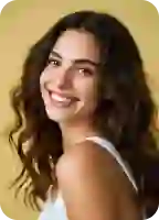 Una foto profesional de la cabeza de una mujer con una chaqueta gris, sonriendo y con un fondo neutro y limpio.